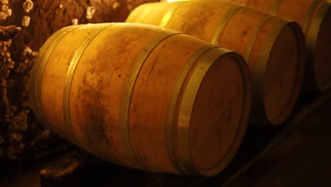 barriles de vino envejecidos en un sótano débilmente iluminado
