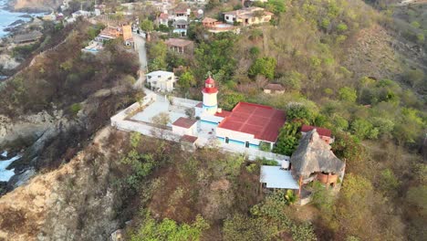 Vista-Orbital-Del-Pequeño-Faro-Sobre-El-Acantilado-En-La-Tarde,-En-La-Costa-De-Oaxaca