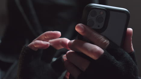 an annoyed person wearing a mask takes out a phone from their pocket and starts using it
