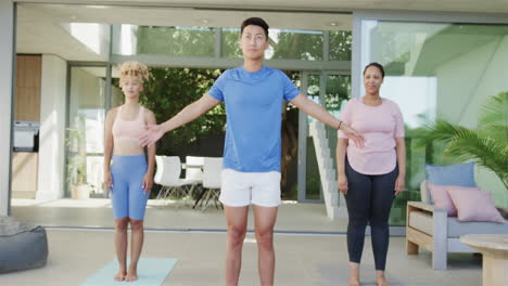 young asian man leads a yoga session at home