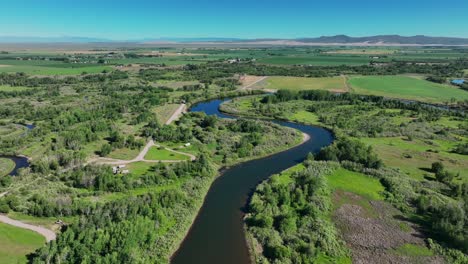 idyllic scenery of river and lush fields in saint anthony, idaho, united states - aerial drone shot