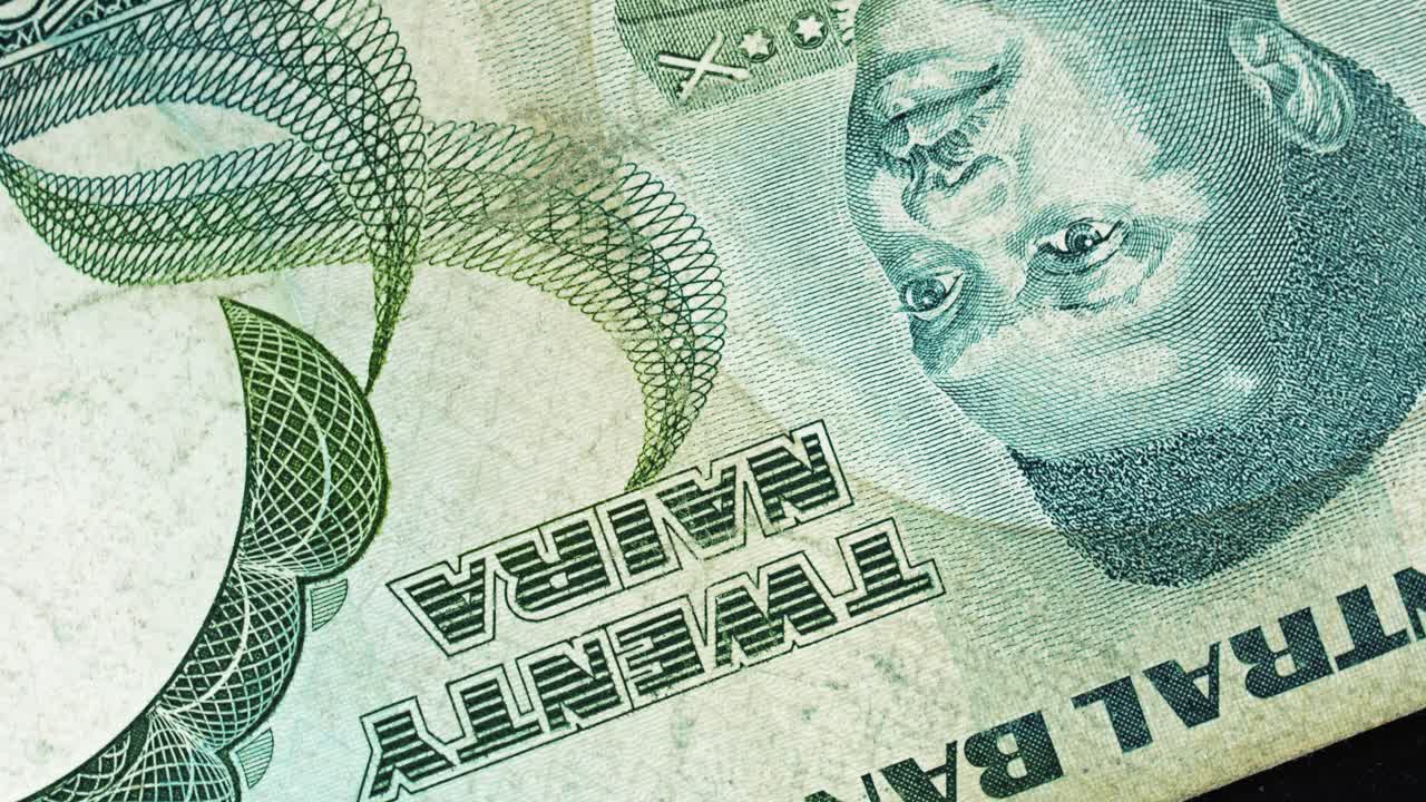 Nigeria 20 Naira banknote obverse with portrait and "Twenty Naira" text rotating on black background