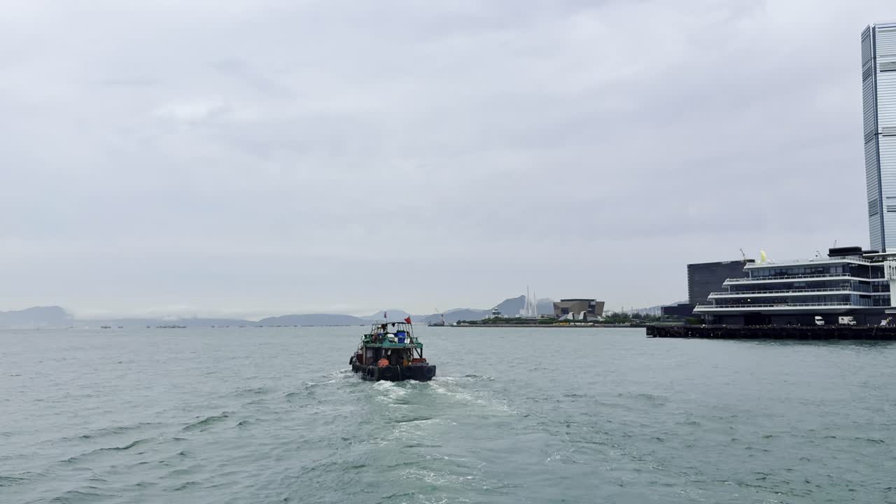 Footage captured from a ferry in Hong Kong, showcasing the city skyline, bustling harbor, moving vessels, and waterfront activity, highlighting the dynamic energy and scenic beauty of Victoria Harbour