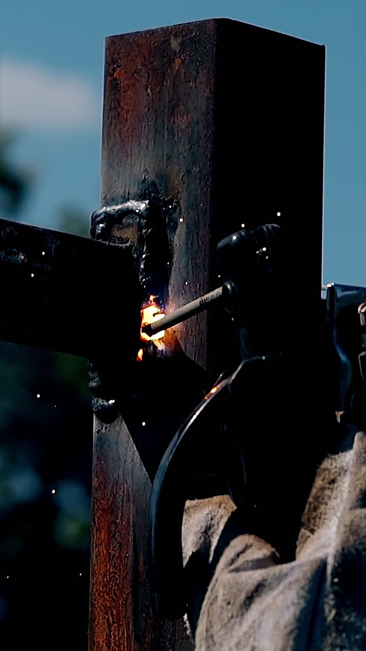 handyman welds fence metal carcass with machine tools in spring evening closeup backside view
