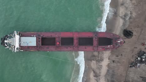 Vista-Aérea-De-Pájaro-Sobre-La-Playa-Con-Un-Gran-Barco-Varado-En-El-Patio-De-Desguace-De-Gadani