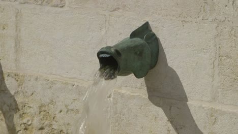 Fountain-detail-representing-a-fish-with-an-opne-mouth-filmed-in-Lisbon,-Portugal