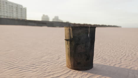 Gray-metal-garbage-bin-or-trash-can-on-the-beach