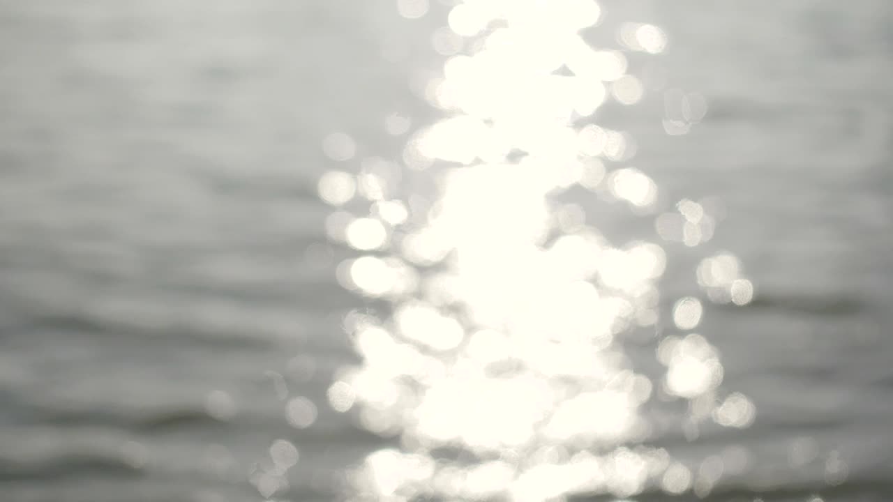 la superficie del río brilla bokeh el agua que fluye fuera de foco brilla en la tarde.4k