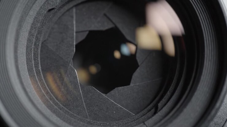 Primo piano del meccanismo del diaframma di un obiettivo fotografico, che rivela il design intricato e la funzionalità delle lamelle nel controllo della luce e dell'esposizione.