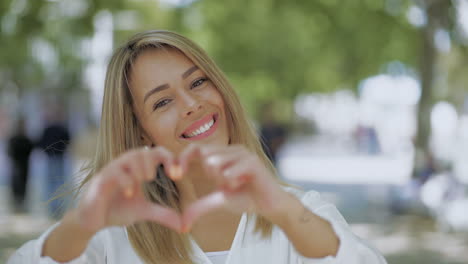 attractive happy girl showing hand heart