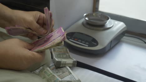 Close-up-shots-of-hands-counting-2000-Indian-rupee-banknotes-after-a-transaction