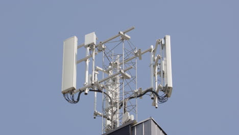 Statischer-Rack-Fokus-Auf-5G-Mobilfunkmast-Vor-Blauem-Himmel,-Teleobjektiv