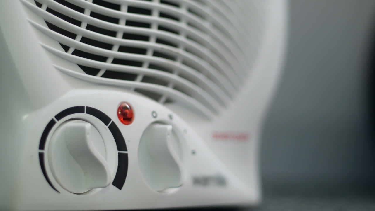 A man turning off a fan heater