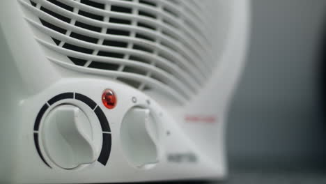 un hombre apagando un calentador de ventilador