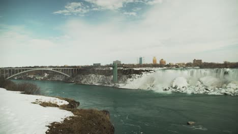 niagara falls and the rainbow bridge in snowy winter, wide static view