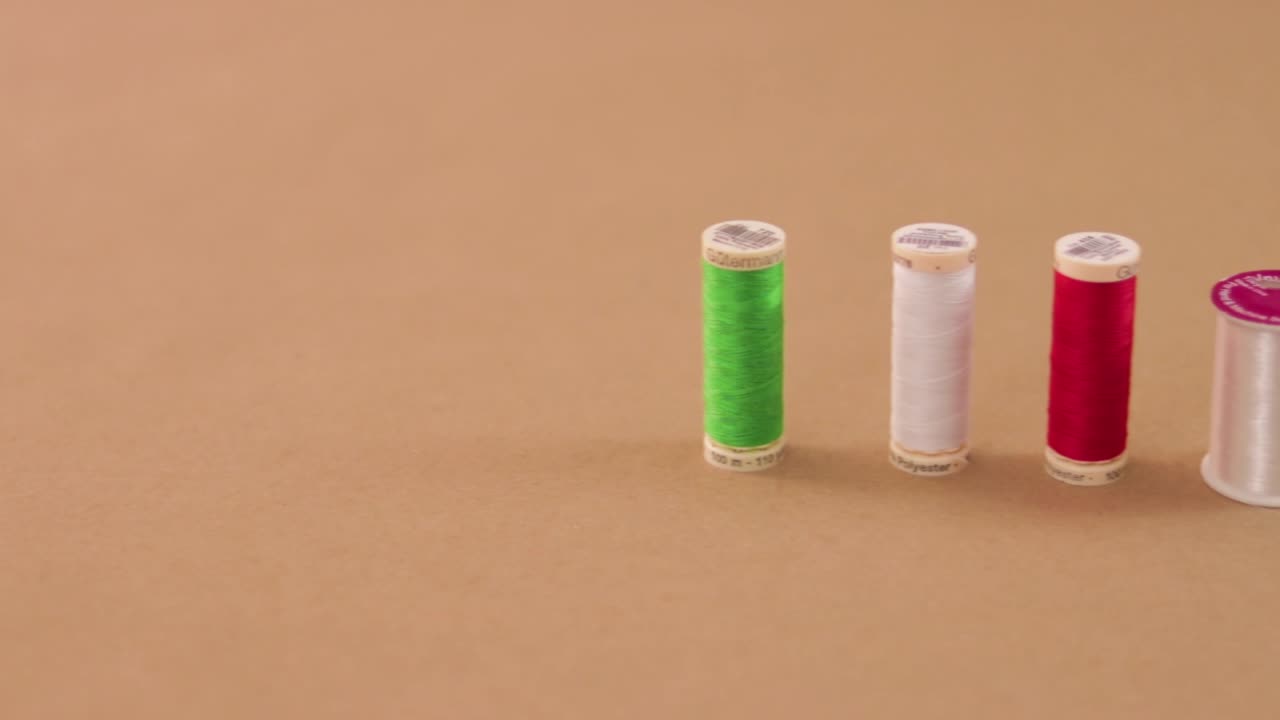 hilos de coser organizados en una línea horizontal. panorámica