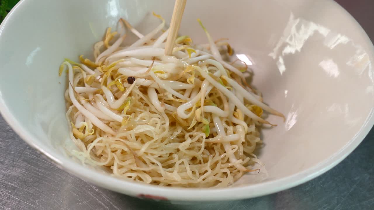 Noodle Tom Yum in stile thailandese, contenenti noodles all'uovo, carne di maiale macinata, fegato e interiora di maiale, germogli di soia, spezie e arachidi tritate, uno dei cibi di strada preferiti in Thailandia