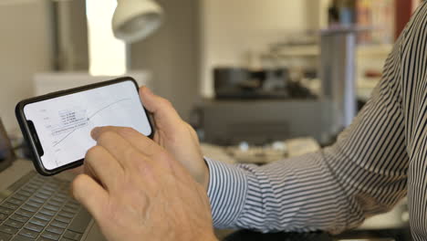primer plano de un hombre después de aumentar las ganancias del mercado de valores en un teléfono inteligente con el dedo