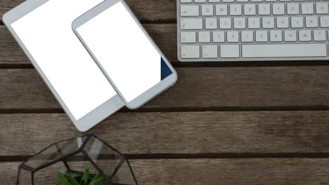 video of tablet and smartphone with blank screens and keyboard on wooden background