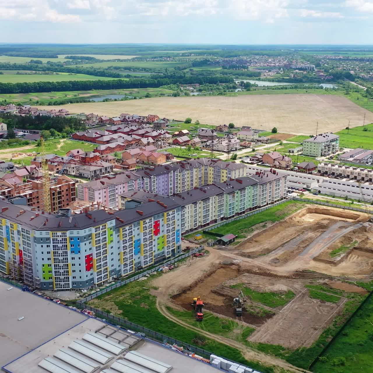 Modern residential complex in the countryside. Colorful high-rise buildings on a construction site. New microdistrict is building. Aerial view