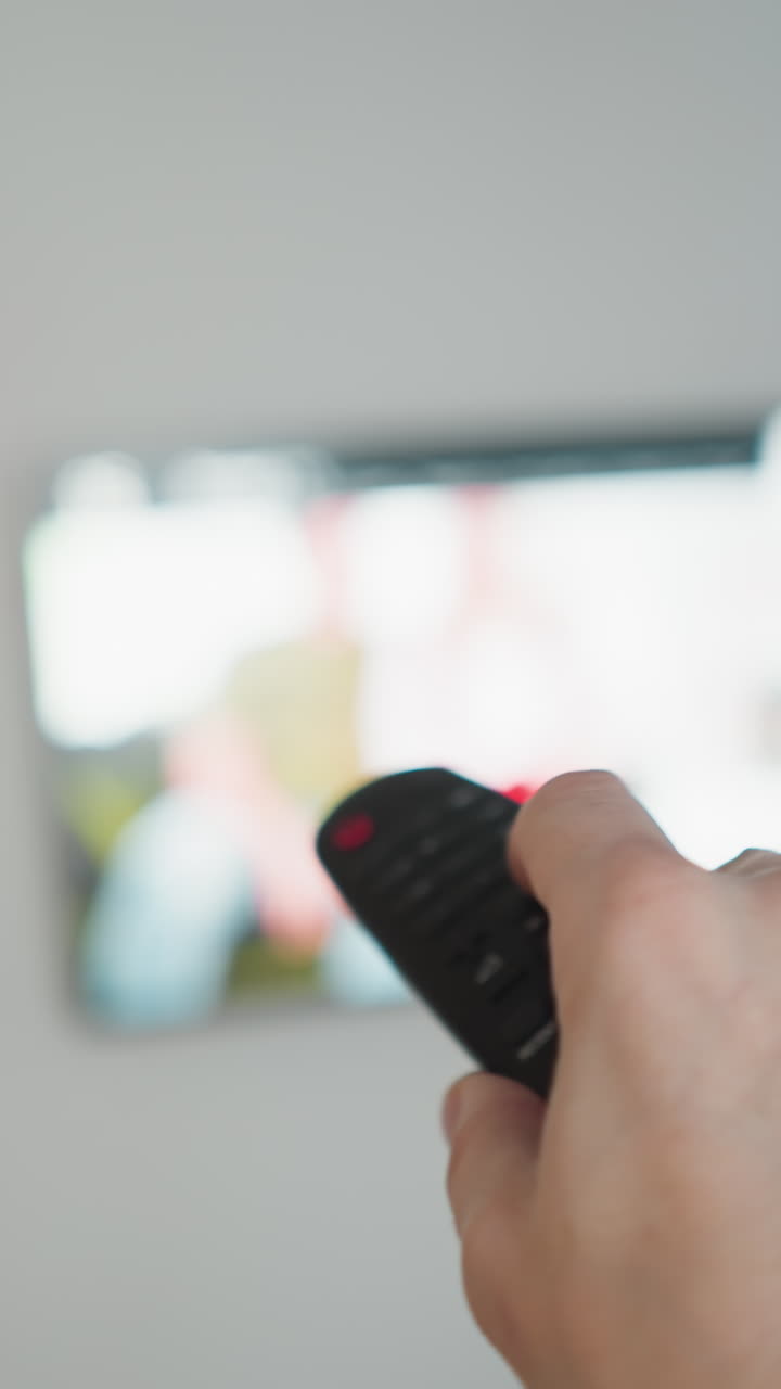 tv 앞에서 리모컨을 들고 있는 손, 흐릿한 크리스마스 트리, pov