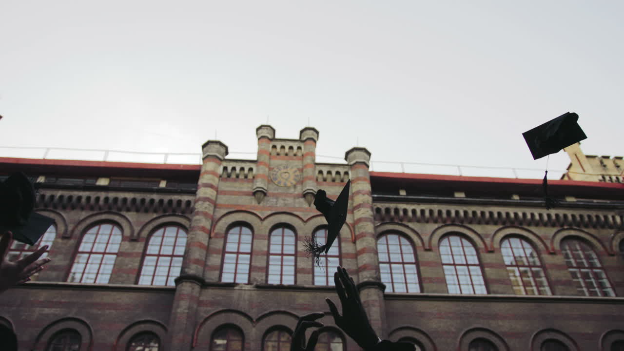 통로를 통해 졸업생을 걷고 검은 모자를 던지는 뒷모습