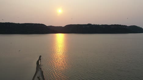 sunset over a river with mountains