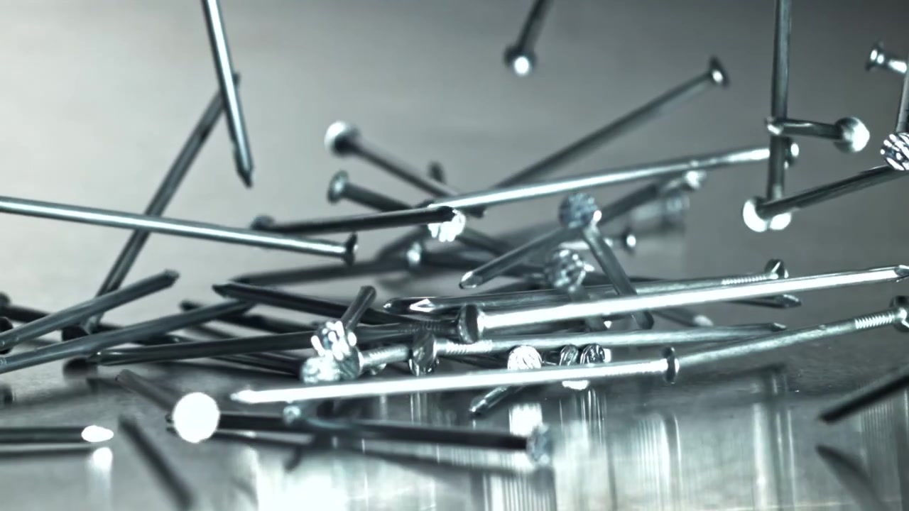 Metal Nails Falling in Slow Motion onto a Reflective Surface