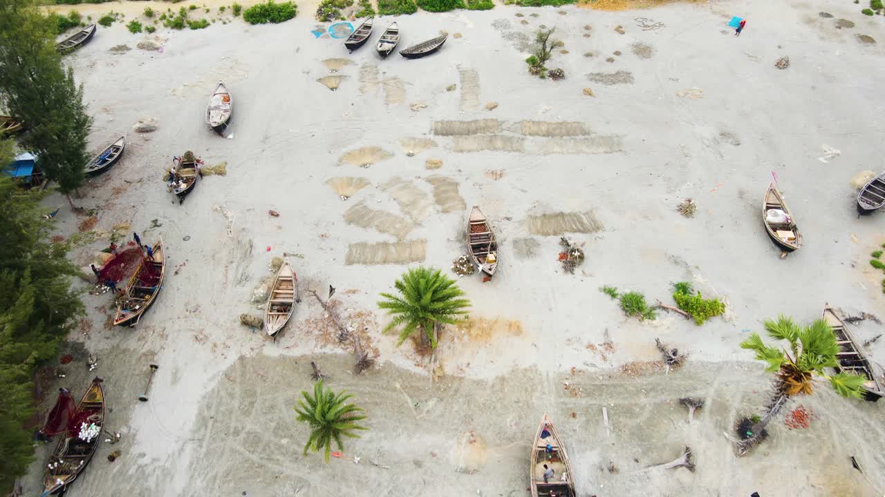 Barche da pesca e reti da pesca che giacciono sulla riva sabbiosa in Bangladesh, Asia meridionale