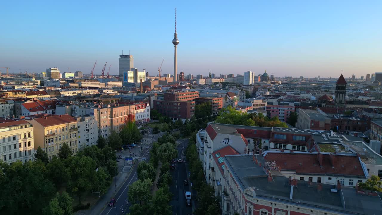 la torre de televisión de berlín se eleva por encima de los tejados y un sitio de construcción en senefelderplatz durante la puesta del sol. vista aérea suave rampa de velocidad de vuelo hipermovimiento lapso de tiempo