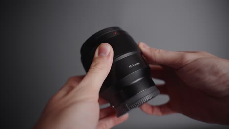 Portrait-85mm-lens-hold-in-the-hand-on-the-grey-background