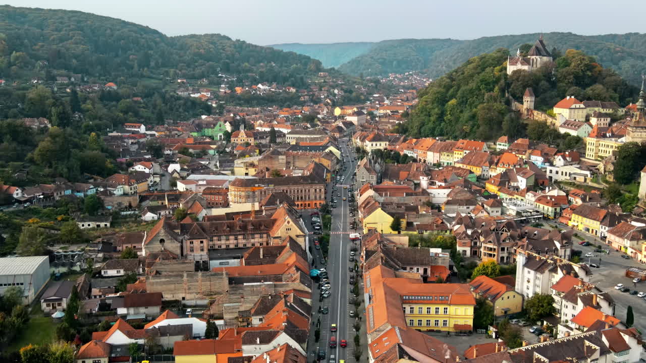 Aerial drone view of the Historic Centre of Sighisoara, Romania. Old buildings, streets with cars, greenery
