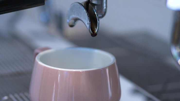 Substituição de xícara de café e porta-filtro em máquina de café, em cafeteria iluminada, close-up