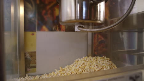 popcorn production machine. popcorn falling out of metal vat in slow motion