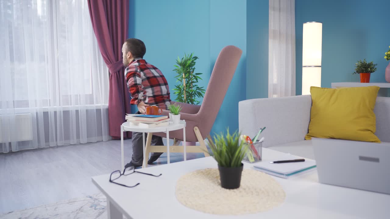 un joven enano inválido y aburrido mirando por la ventana.