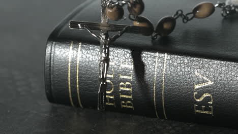 rosary beads falling onto a bible