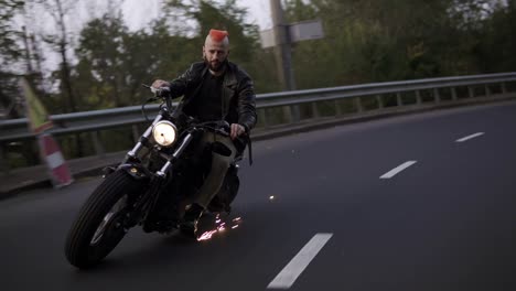 frontview of a man riding on a motorcycle on a turn clings to the asphalt, sparks fly