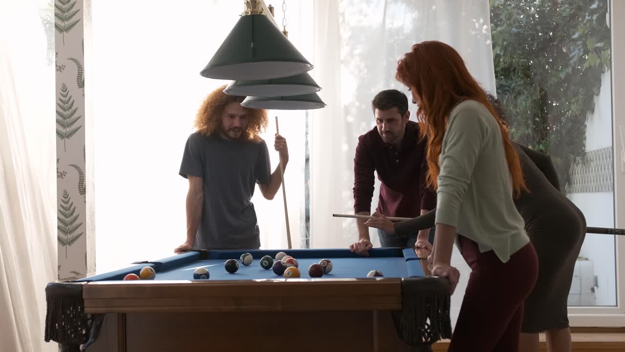 Black woman hitting ball into pocket while playing pool game