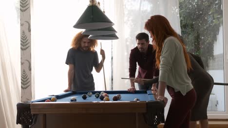 black woman hitting ball into pocket while playing pool game