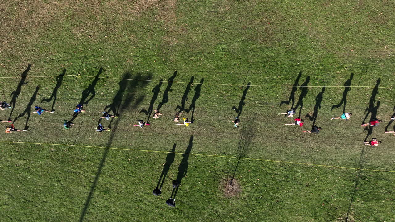 잔디 코스에서 경주하는 달리기 선수들의 실루