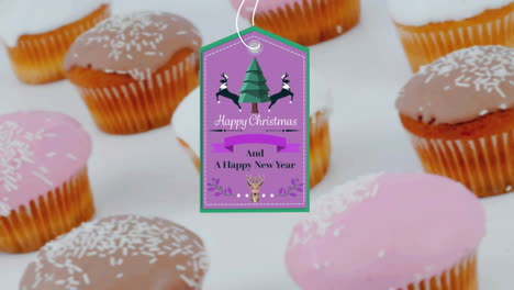 animation of christmas greetings on tag over cupcakes on white background