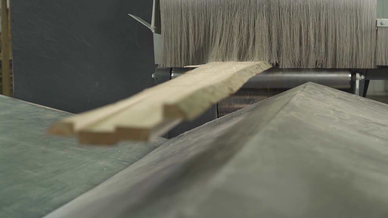 A close-up demonstration of a wood piece being cut by industrial automatic slicing system.