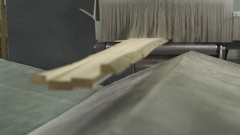 a close-up demonstration of a wood piece being cut by industrial automatic slicing system.