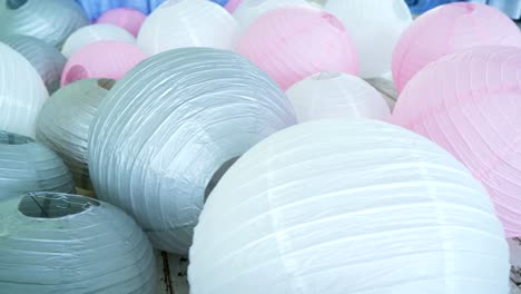 colorful white pink gray paper lanterns set on floor.