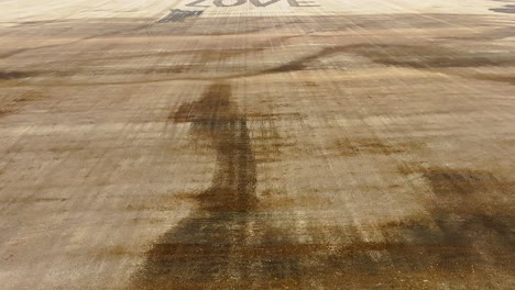 drone booming up over a field where the word 'love' is tilled into the stubble