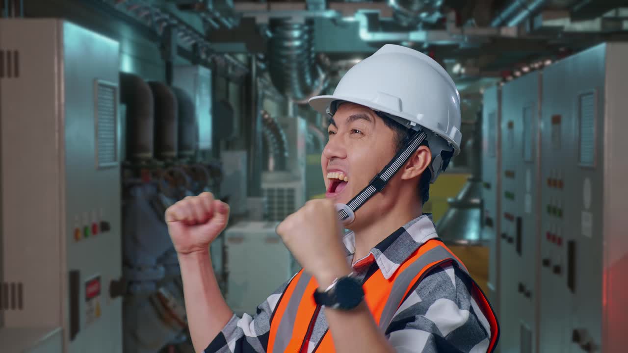 Close Up Of Side View Of Asian Male Engineer With Safety Helmet Screaming Goal Celebrating Working In Engine Control Room, Work Of Electrical Generators