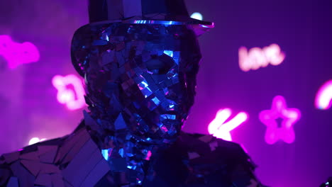 funny diamond man dancing making hand movements in neon blue purple light. metal suit made of silver.