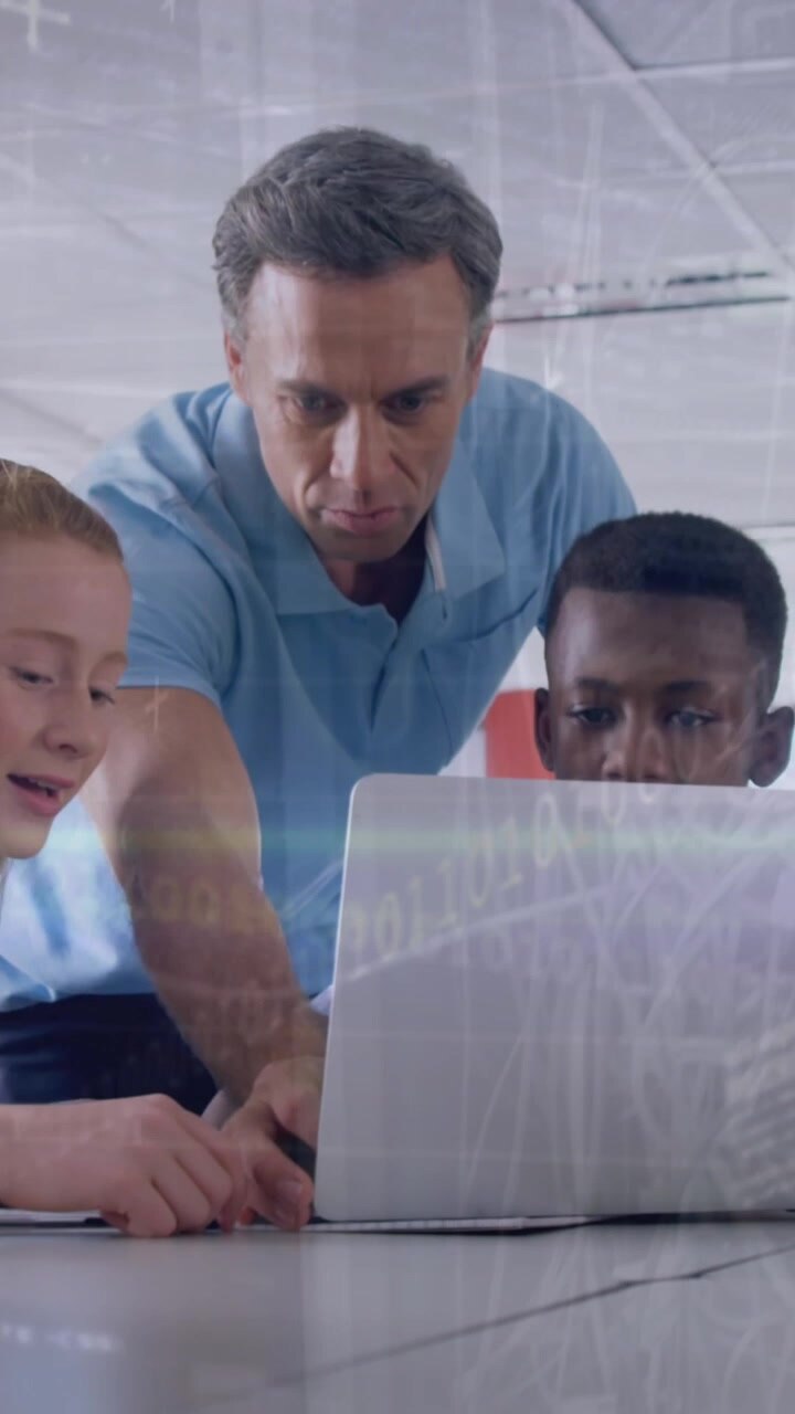 Animation of coding and graph over diverse male teacher explaining students over laptop in classroom