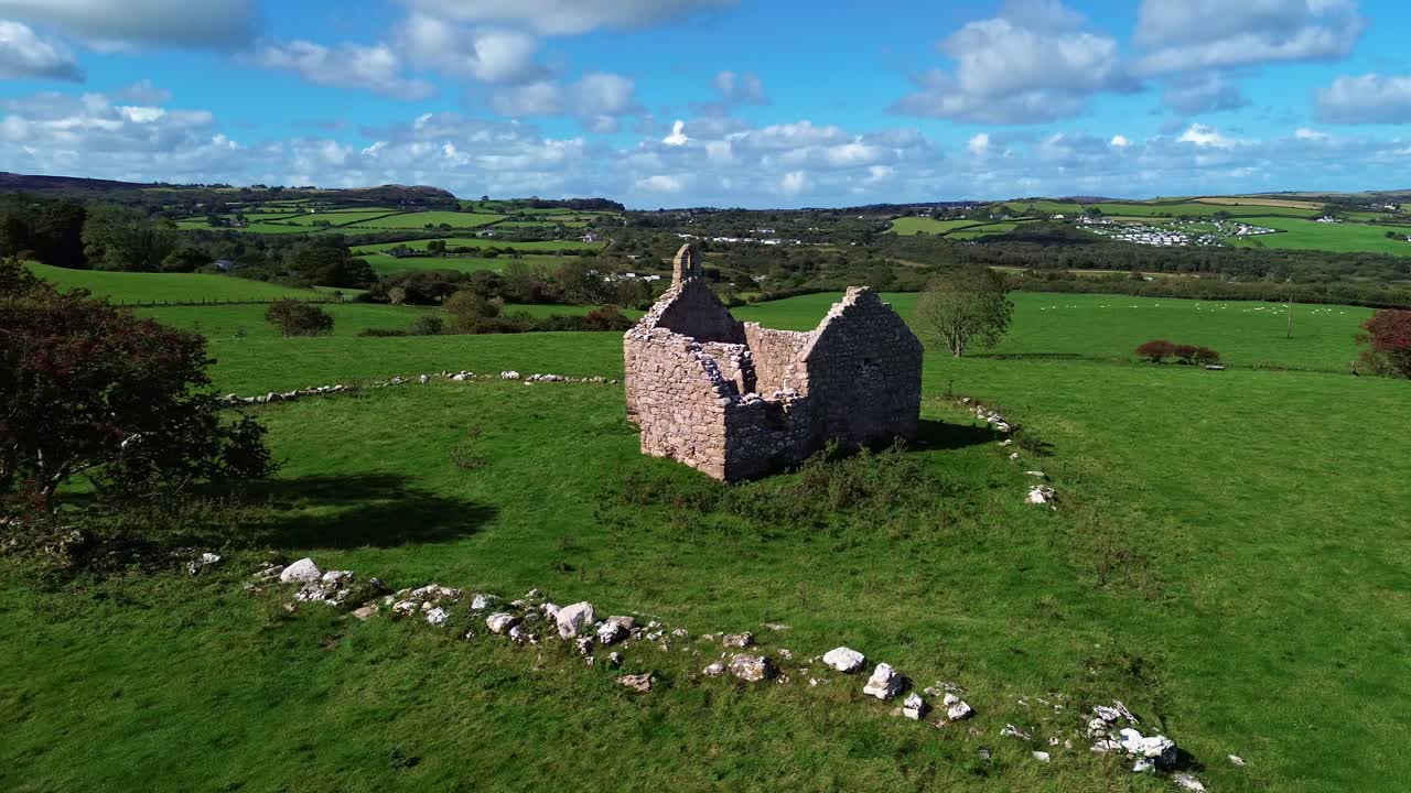 Lligwy chapel aerial view approaching medieval churchyard ruins on lush meadow farmland