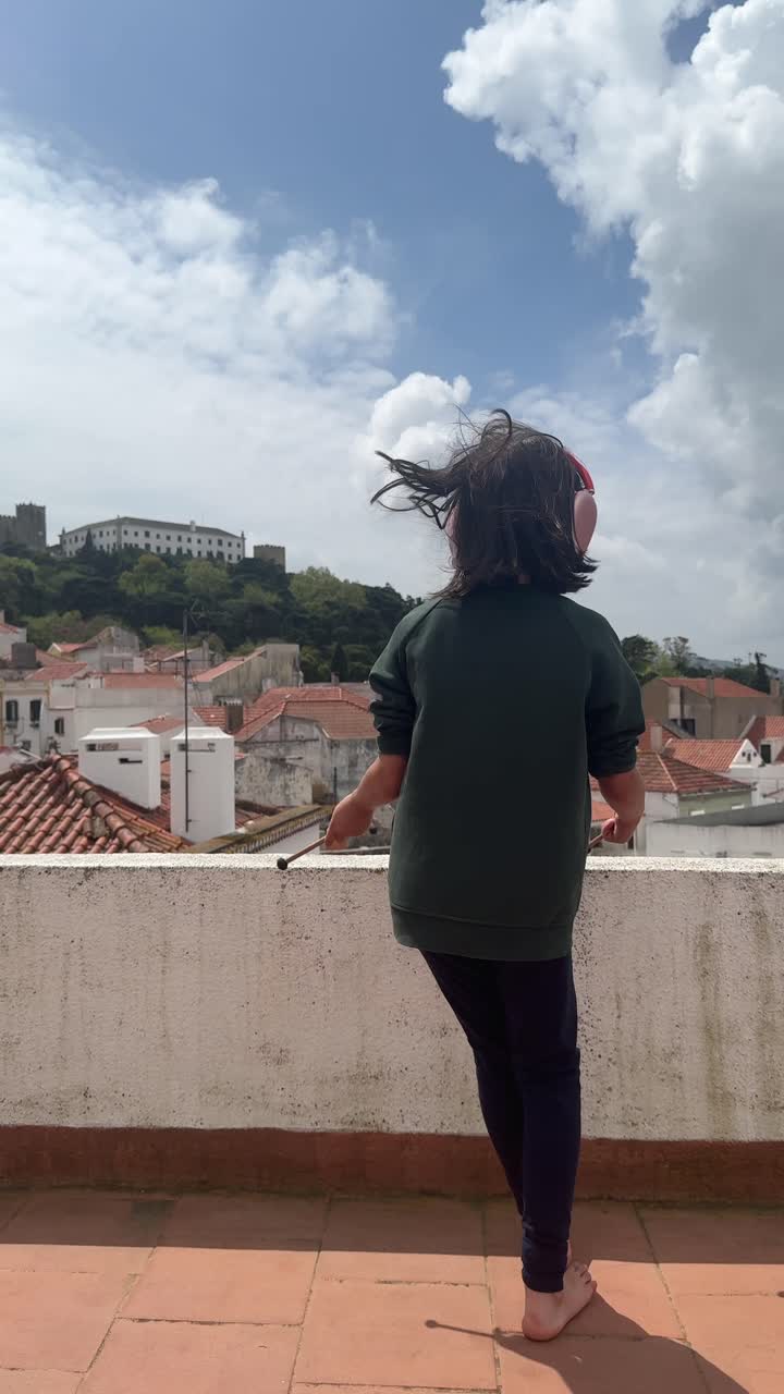 Child with headphones on a rooftop in Portugal